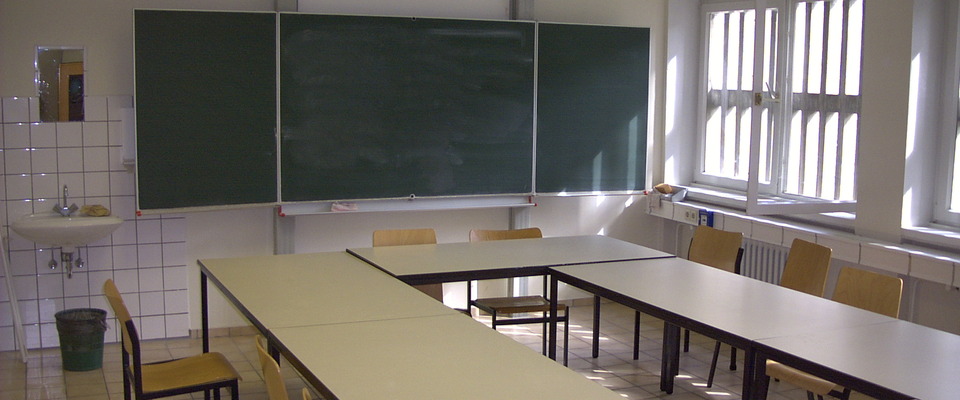 Schulraum mit Tafel und Klassenbänke
