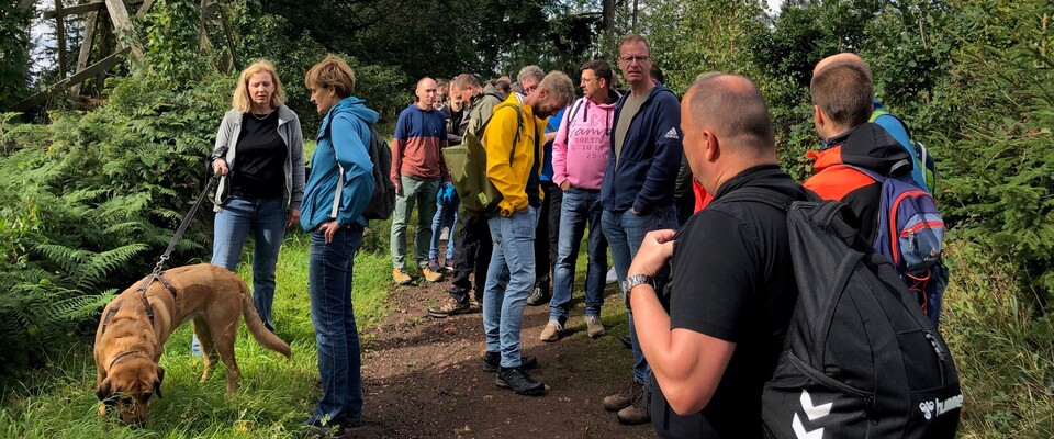 Wandertag JVA Schwerte 2023 Gruppe im Wald vor Jagdhochstand