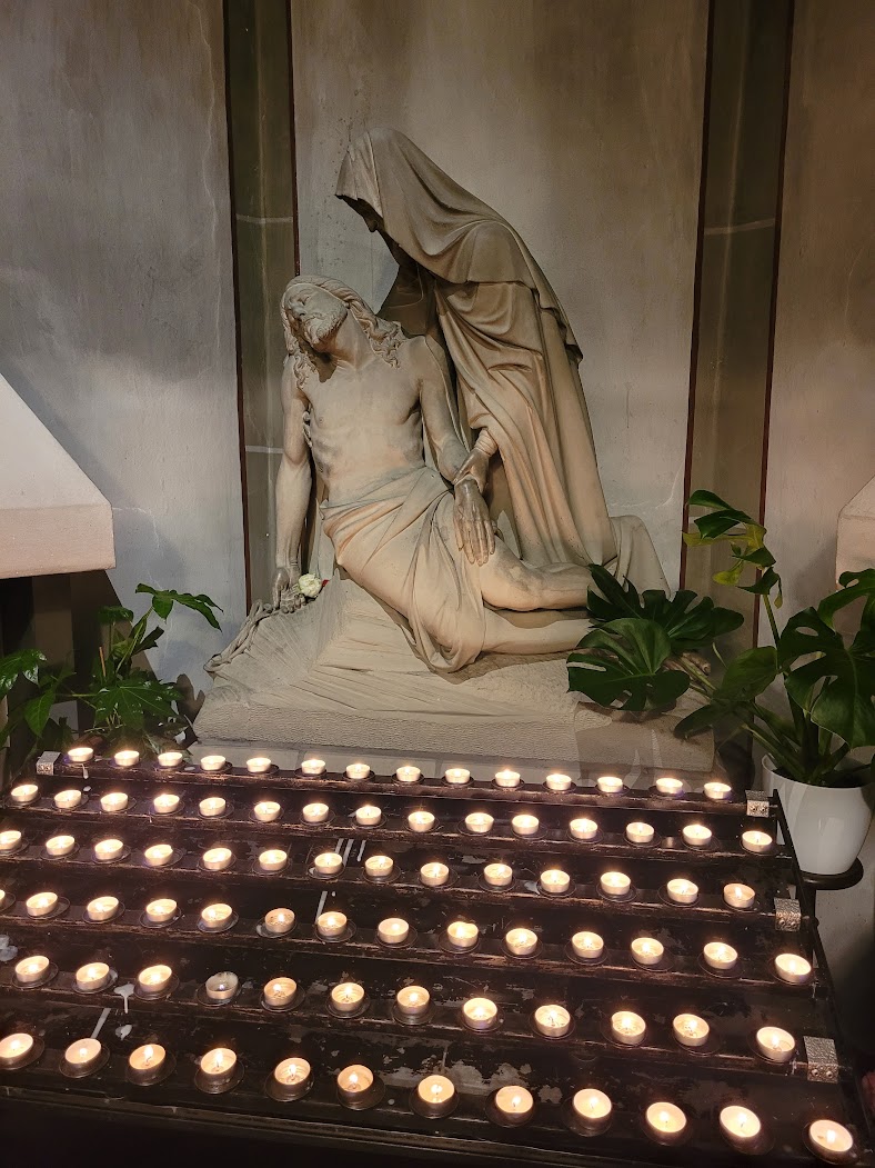 Maria und Jesus Statue mit zahlreichen Kerzen davor